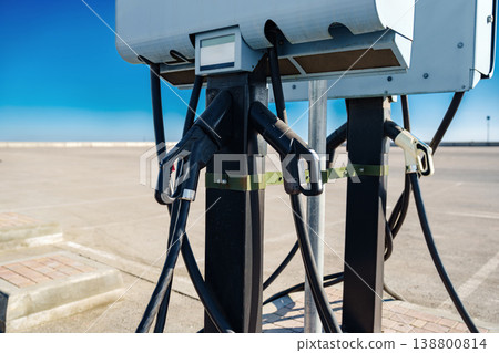 Electric car charger located at a parking lot under a clear sky in daytime Electric car charger located at a parking lot under a clear sky in daytime 138800814