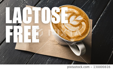 Coffee in a cup with a design on top, placed on a wooden table with a note about being lactose free 138800816