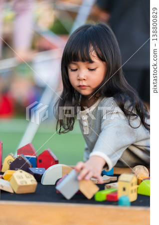 preschool child girl playing with wooden toy block at outdoor 138800829