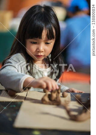 preschool child girl with sculpting from plasticine at outdoor park preschool child girl with sculpting from plasticine at outdoor park 138800834