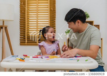 cheerful father and child girl drawing and painting with colorful oil pastels on paper 138800919