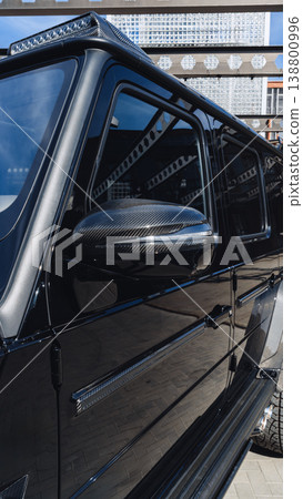 Close view of a black luxury vehicle parked in an urban area during daylight 138800996