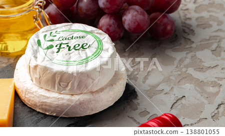 Lactose free cheese with grapes and honey on a stone surface in a kitchen setting Lactose free cheese with grapes and honey on a stone surface in a kitchen setting 138801055