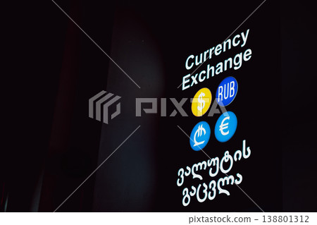 Currency exchange sign shows different currencies in a city at night Currency exchange sign shows different currencies in a city at night 138801312