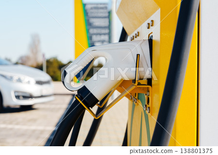 Charger for electric car in a parking area during daylight Charger for electric car in a parking area during daylight 138801375