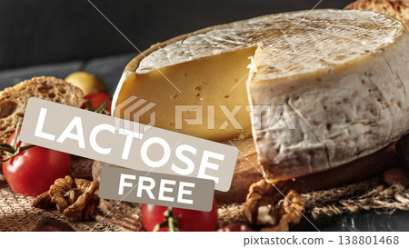 Cheese on a wooden board with red tomatoes and nuts at a table setting in a kitchen Cheese on a wooden board with red tomatoes and nuts at a table setting in a kitchen 138801468