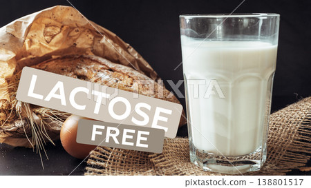 Glass of lactose free milk with bread and an egg on a dark surface in a kitchen setting 138801517