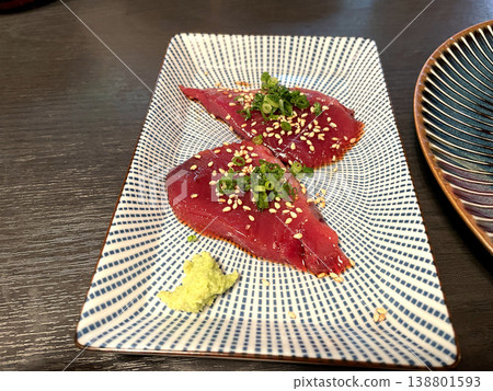 醃製鰹魚片，盛於方盤中，佐以芝麻和蔥花。 138801593
