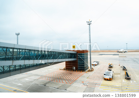 View of airport terminal at gate 103 with planes and vehicles on the tarmac View of airport terminal at gate 103 with planes and vehicles on the tarmac 138801599