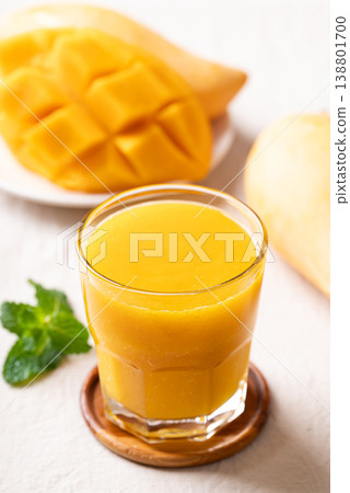 Fresh mango smoothie in a glass with ripe mango slices, refreshing summer drink 138801700