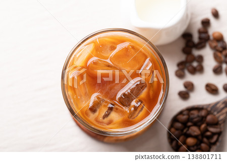 Iced latte coffee in a glass with roasted coffee beans. Popular refreshing summer drink Iced latte coffee in a glass with roasted coffee beans. Popular refreshing summer drink 138801711