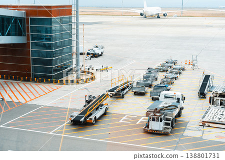 Airport ground services prepare luggage for an arriving flight at a busy terminal Airport ground services prepare luggage for an arriving flight at a busy terminal 138801731