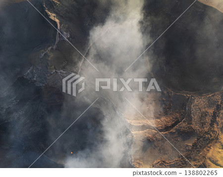 Lava flow and smoke seen from above a volcanic area during the day 138802265