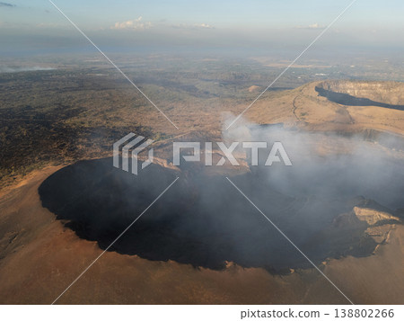 View of volcano crater with smoke rising from the center 138802266