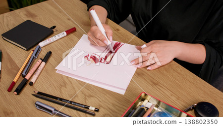 Tailor draw. Garment draft. Creative female seamstress artist hand pen sketching idea for new clothing model concept on studio table. Tailor draw. Garment draft. Creative female seamstress artist hand pen sketching idea for new clothing model concept on studio table. 138802350