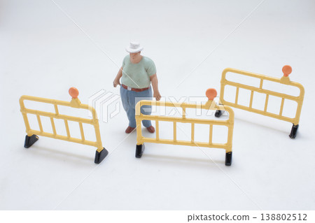 Miniature Figure Surrounded By Safety Barriers 138802512