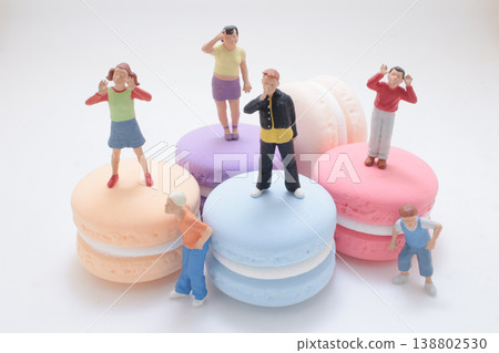 Miniature Figures Standing On Colorful Macarons Miniature Figures Standing On Colorful Macarons 138802530