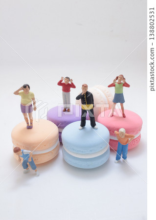 Miniature Figures Standing On Colorful Macarons 138802531
