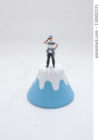 Miniature Figure Standing Atop Stylized Peak Miniature Figure Standing Atop Stylized Peak 138802535