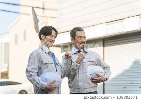 一群男性工人站在居民區。 一群男性工人站在居民區。 138802571