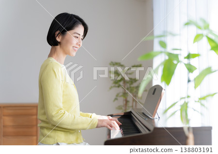 一位女士在家彈奏電子鋼琴 138803191