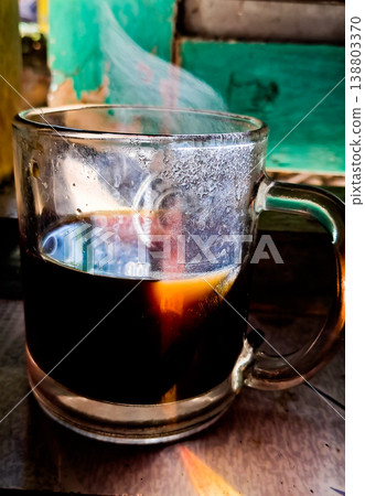 close up image of a cup of hot coffee with smoke coming from the cup close up image of a cup of hot coffee with smoke coming from the cup 138803370