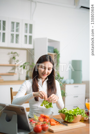 Healthy Asian woman cooking at home, chopping fresh vegetables for clean eating, detox smoothie and meal prep. Nutrition, diet, wellness Healthy Asian woman cooking at home, chopping fresh vegetables for clean eating, detox smoothie and meal prep. Nutrition, diet, wellness 138803684