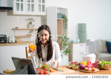 Healthy Asian woman mixing fresh salad at home kitchen with vegetables and juice. Clean eating, meal prep, nutrition diet, wellness lifestyle Healthy Asian woman mixing fresh salad at home kitchen with vegetables and juice. Clean eating, meal prep, nutrition diet, wellness lifestyle 138803692