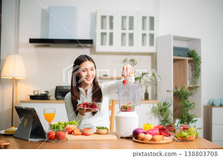 Healthy Asian woman making detox smoothie at home kitchen, adding fresh fruits and vegetables to blender. Clean eating, nutrition diet, wellness lifestyle Healthy Asian woman making detox smoothie at home kitchen, adding fresh fruits and vegetables to blender. Clean eating, nutrition diet, wellness lifestyle 138803708