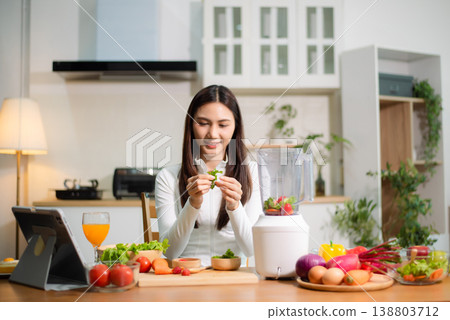 Healthy Asian woman making detox smoothie at home kitchen, adding fresh fruits and vegetables to blender. Clean eating, nutrition diet, wellness lifestyle Healthy Asian woman making detox smoothie at home kitchen, adding fresh fruits and vegetables to blender. Clean eating, nutrition diet, wellness lifestyle 138803712
