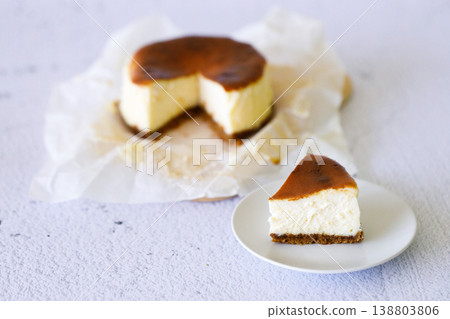 Cheesecake with baking paper on white marble table. Cheesecake with baking paper on white marble table. 138803806