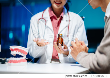 Dentist explaining medicine and oral treatment to patient during consultation. Concept of dental care, healthcare advice, and professional medical support. Dentist explaining medicine and oral treatment to patient during consultation. Concept of dental care, healthcare advice, and professional medical support. 138803892
