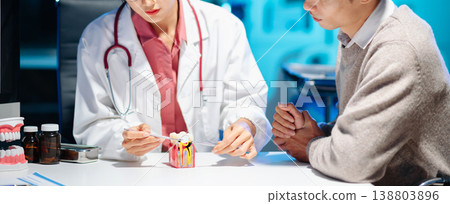 Dentist explaining medicine and oral treatment to patient during consultation. Concept of dental care, healthcare advice, and professional medical support. 138803896