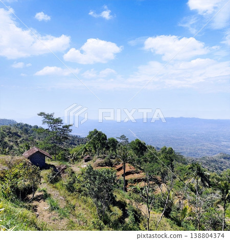 view of the land from the top of the hill with a cloudy blue sky view of the land from the top of the hill with a cloudy blue sky 138804374