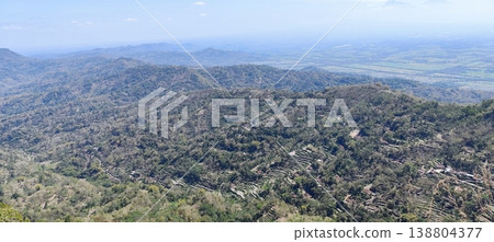 view of the land from the top of the hill with a cloudy blue sky 138804377