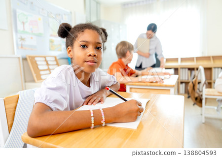 Portrait of American American girl hold the pencil to write something and look at camera with little smile. Portrait of American American girl hold the pencil to write something and look at camera with little smile. 138804593