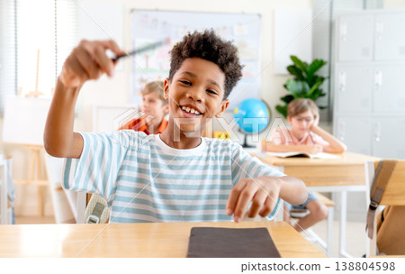Portrait of American American boy hold the pencil and action with fun activities also look at camera with smiling. Portrait of American American boy hold the pencil and action with fun activities also look at camera with smiling. 138804598