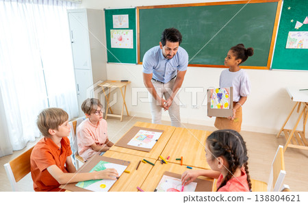 The teacher ask the question and guide for African American girl to present her drawing and painting in front of the classroom. The teacher ask the question and guide for African American girl to present her drawing and painting in front of the classroom. 138804621