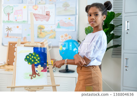 African American stand beside of the painting that she made and she look proud with her creation in the classroom. African American stand beside of the painting that she made and she look proud with her creation in the classroom. 138804636