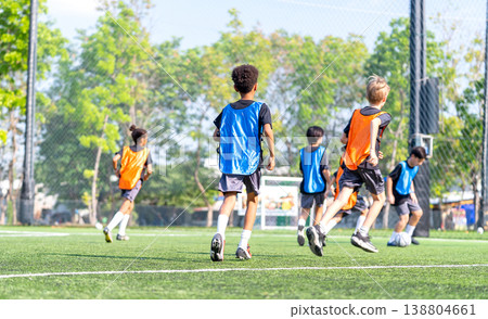 Group of boys and girls enjoy to practice to play soccer together in the field with day light and they look happy to exercise to get good health. Group of boys and girls enjoy to practice to play soccer together in the field with day light and they look happy to exercise to get good health. 138804661