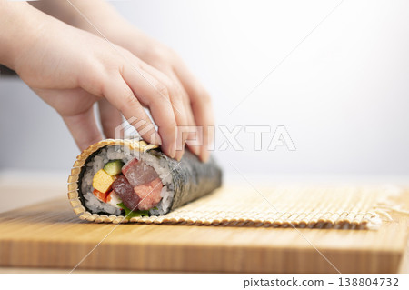 A woman making seafood rolled sushi A woman making seafood rolled sushi 138804732