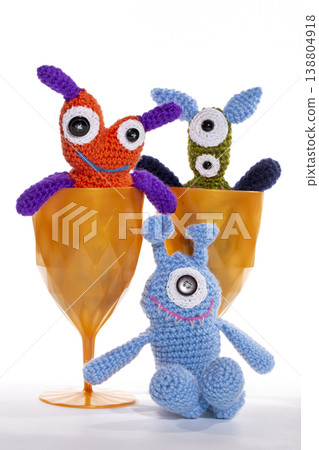 Knitted wool aliens in a glass on a white background Knitted wool aliens in a glass on a white background 138804918