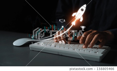 A pair of hands typing on a keyboard with a graphic of a rocket symbolizing growth, innovation, and success in the digital business world. Perfect for finance and technology themes. Sigmoid 138805466