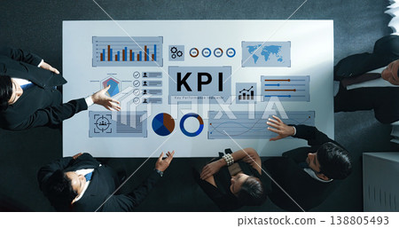Business team analyzing key performance indicators on a table with graphs, charts, and data visuals in a modern office setting for strategic planning Gantry Business team analyzing key performance indicators on a table with graphs, charts, and data visuals in a modern office setting for strategic planning Gantry 138805493