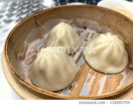 竹蒸籠裡斜放著蒸餃。 竹蒸籠裡斜放著蒸餃。 138805704