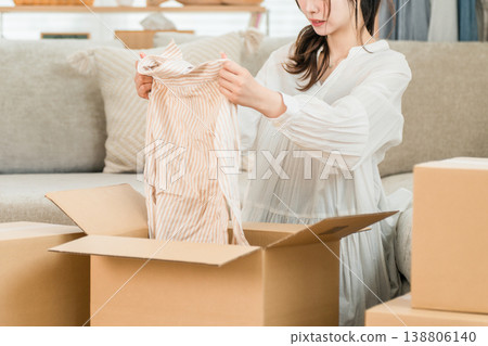 A young woman packing, disposing of, and decluttering at home A young woman packing, disposing of, and decluttering at home 138806140