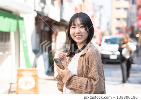 一位年輕女子在舊城區與男友約會，臉上帶著微笑。 138806186