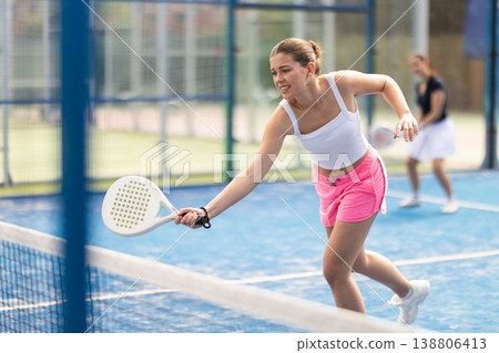 Young woman playing doubles padel tennis Young woman playing doubles padel tennis 138806413