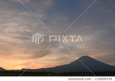 富士山腳下冉冉升起的太陽,以及薄薄的雲朵在天空中灑下的柔和晨光。 富士山腳下冉冉升起的太陽,以及薄薄的雲朵在天空中灑下的柔和晨光。 138806504