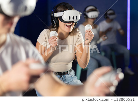 Girl in vr glasses with joysticks playing a video game Girl in vr glasses with joysticks playing a video game 138806551